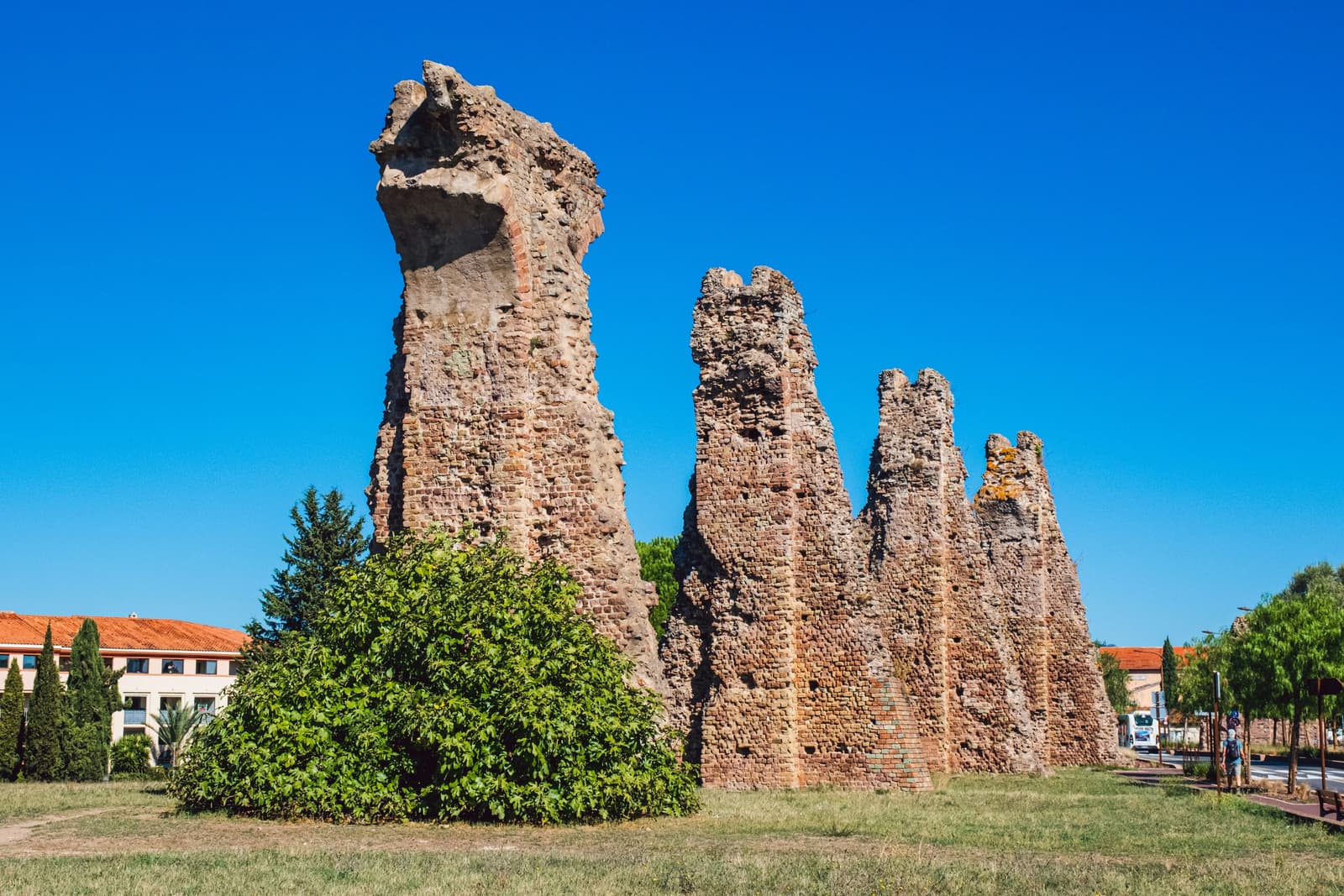The tall piers of the Roman aqueduct of Fréjus under a deep blue sky