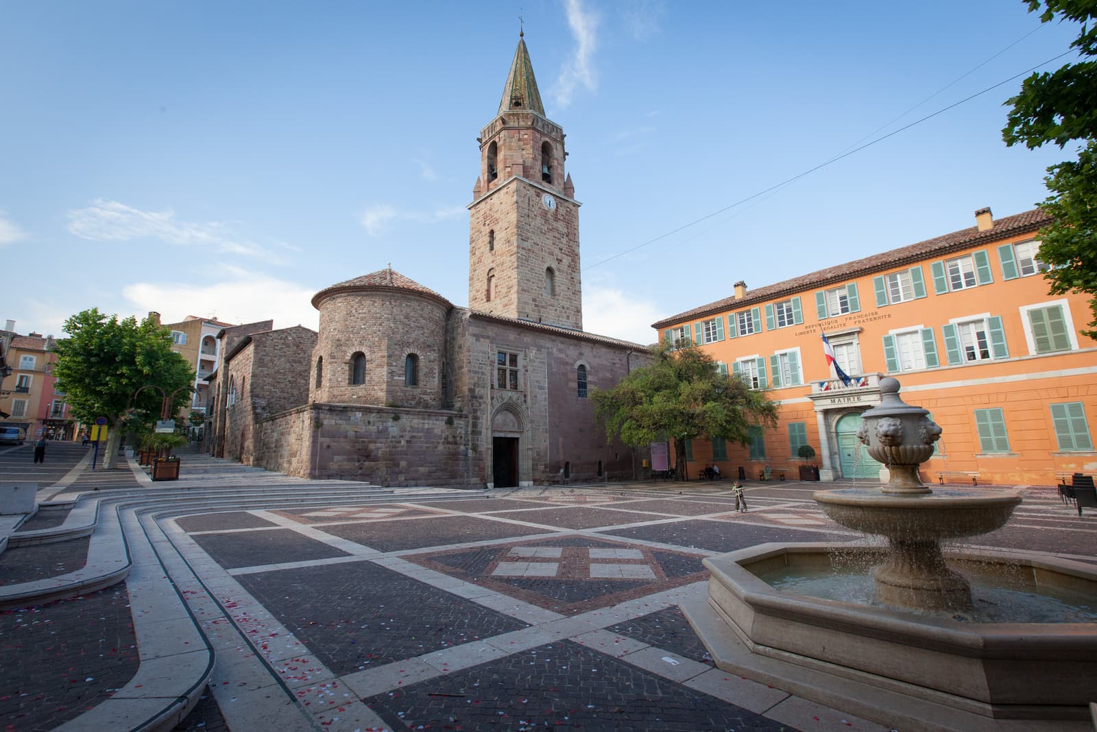 Bell tower of Saint-Léonce cathedral and its paved square with a fountain, in central Fréjus